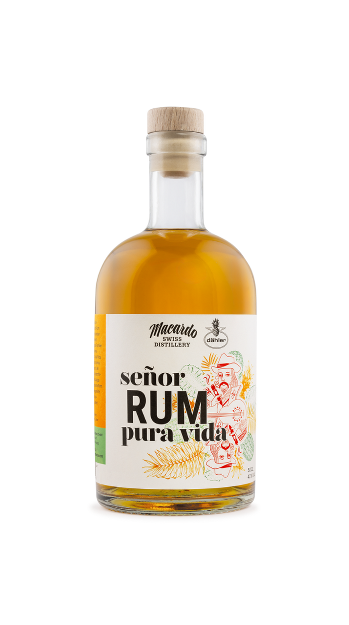 Klare Glasflasche mit goldfarbenem Rum, verschlossen mit Holzstopfen. Etikett mit Schriftzug „Señor Rum Pura Vida“ und Illustration eines Mannes mit Gitarre sowie Ananas-Motiven als Bezug zu costa-ricanischen Ananas.